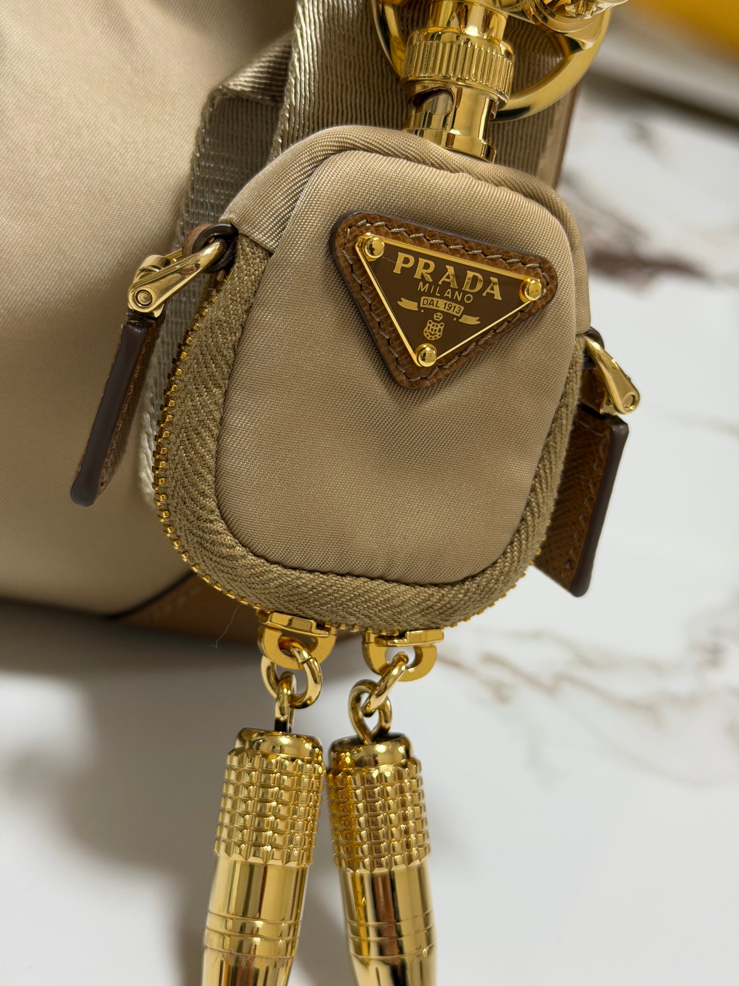 Borsa Prada Re-Edition 2005 in Re-Nylon e Saffiano con ciondolo colore cammello caramello